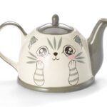 Stoneware ceramic teapot with cat design, with hand-painted manga-style cat face in soft grey tones, featuring big round eyes, blushing cheeks, and striped paws. 1.5L capacity.