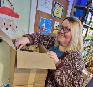 Sabine Weiten smiling while unpacking new stock at the Hebridean Tea Store