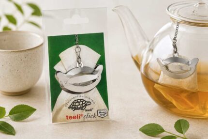 Teeli Click stainless steel tea filter clip attached to glass teapot during tea brewing